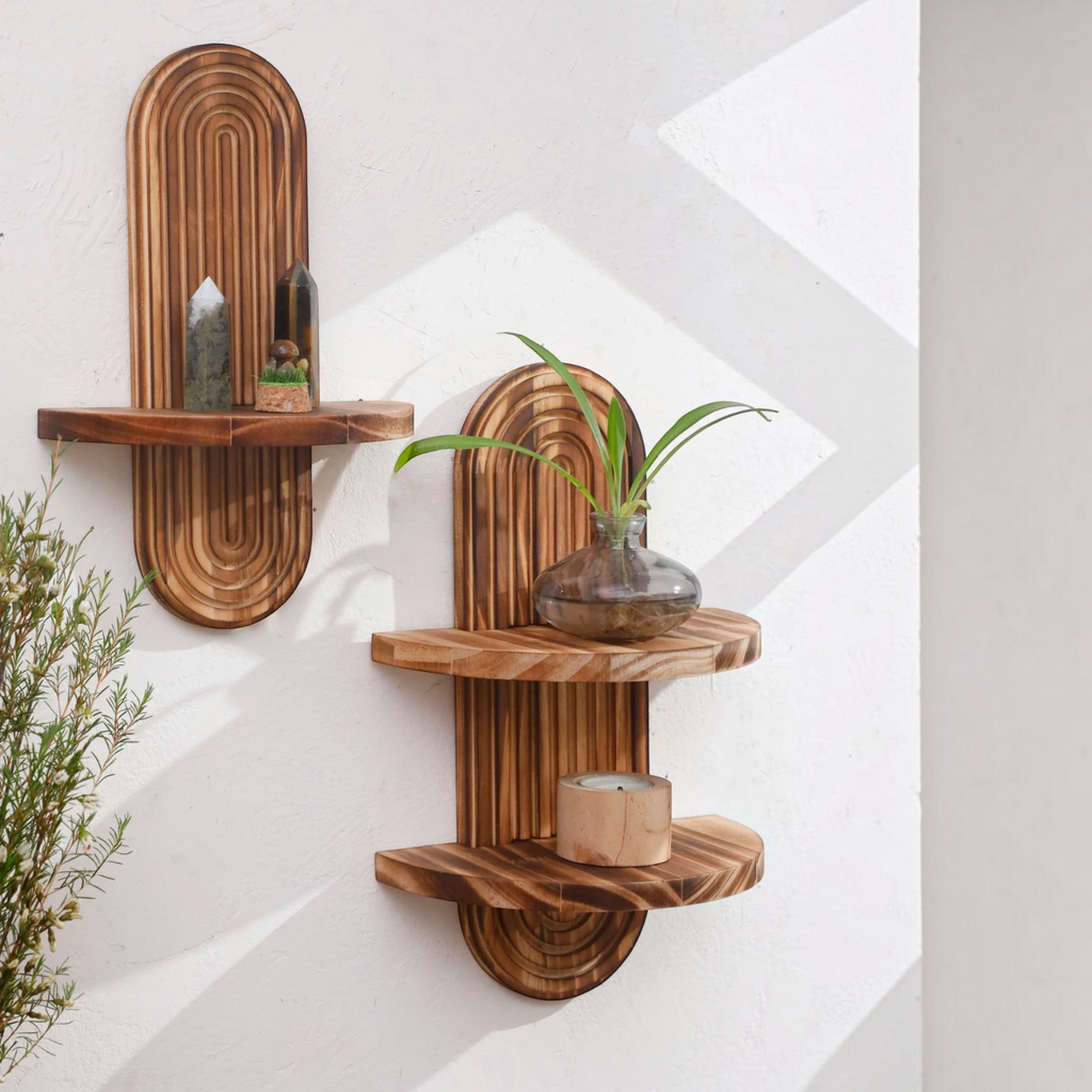 Deux étagères murales Royaume de L'Étagère en bois sculpté avec des motifs arrondis, décorées de plantes et cristaux.
