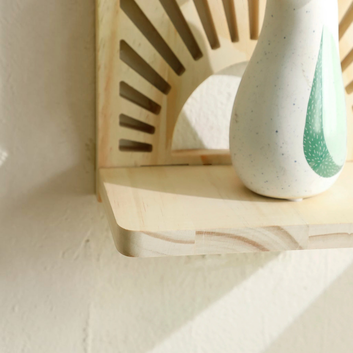 Étagère murale soleil en bois clair Royaume de L'Étagère avec un petit vase décoratif sur la tablette