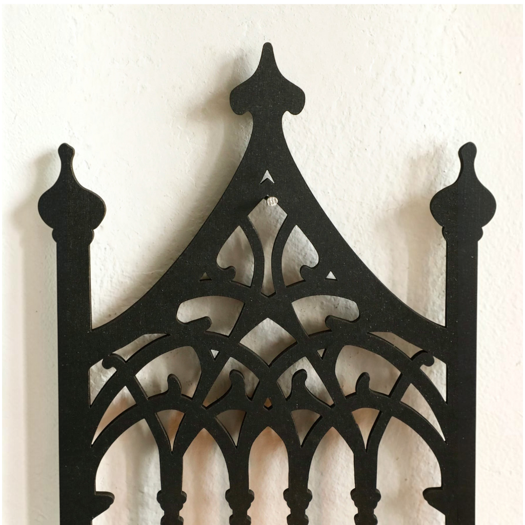 Détail de l'étagère murale en bois noir Royaume de L'Étagère au design gothique avec motifs en arche