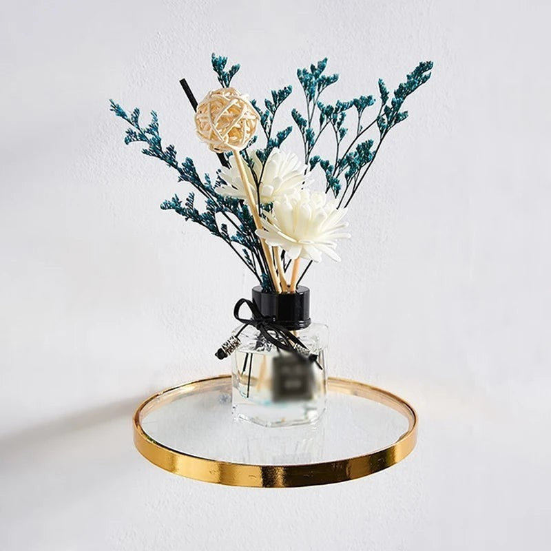 Étagère murale ronde Royaume de L'Étagère avec bordure dorée et plateau en verre supportant un diffuseur de parfum